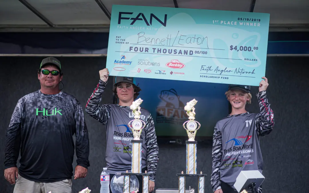 Three men holding up trophies at a fishing tournament.