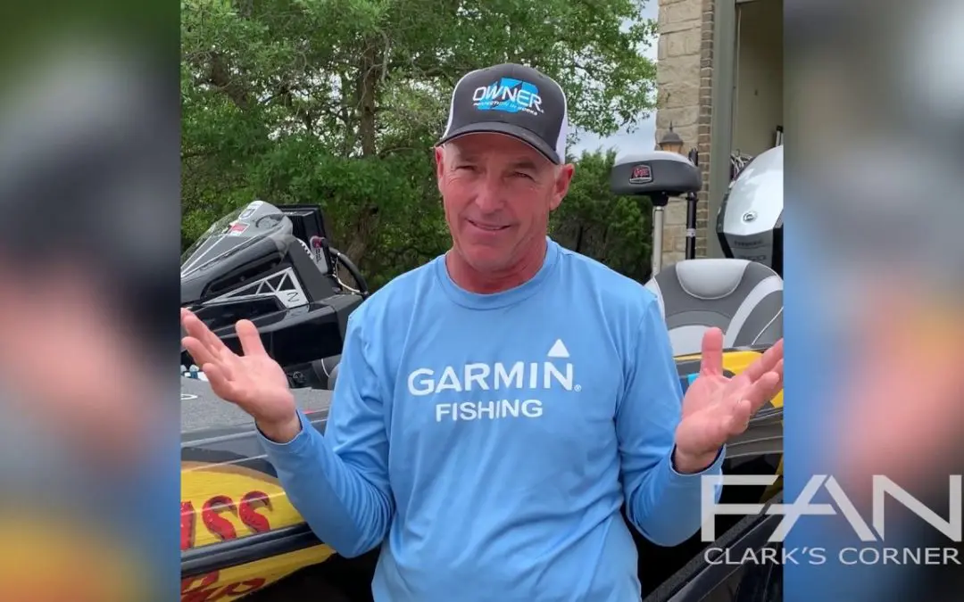 A man is standing next to a garmin fishing boat.