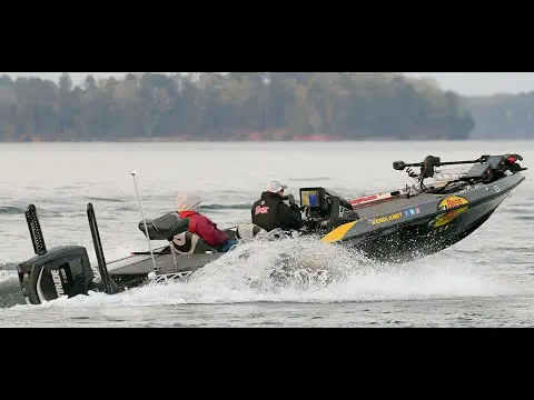 A man in a yellow and black boat on the water.