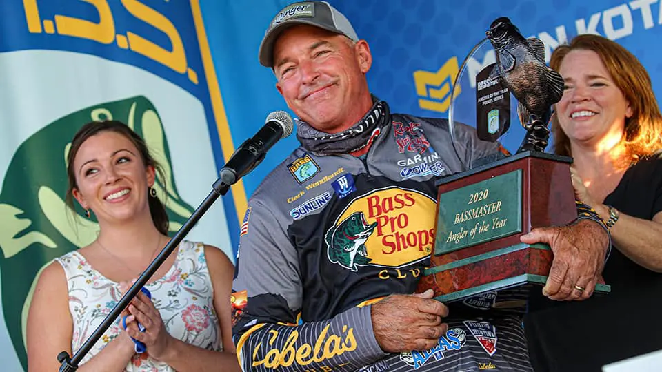 A man is holding a trophy while a woman is holding a microphone.