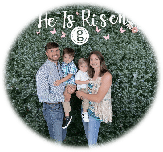 A family is posing for the camera in front of a hedge.