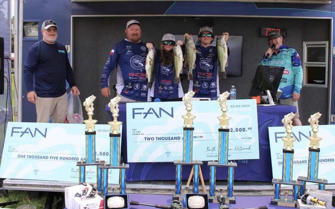 Fishing tournament winners with trophies and checks.