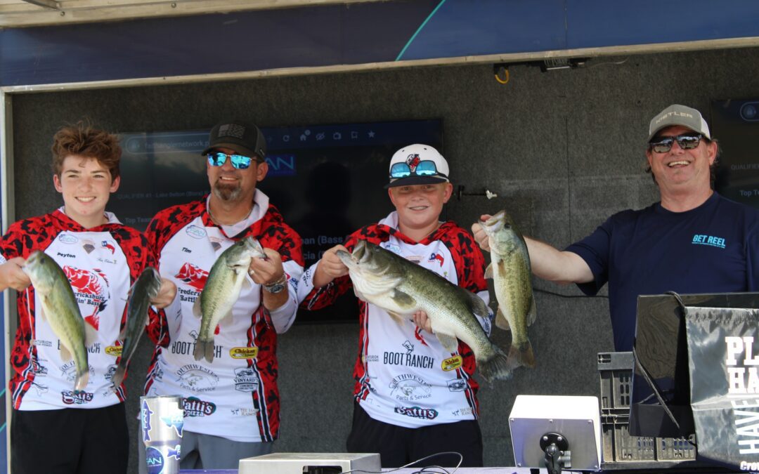 Youth fishing team with large bass.