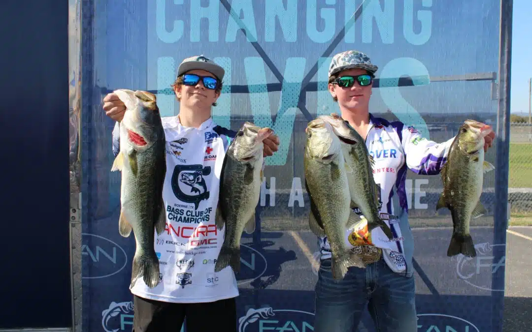 Two anglers holding large bass fish